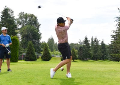 Person swinging gold club on golf course at the 2019 Archway Charity Golf Tournament