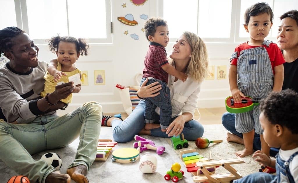 Parents sitting on floor with their children in a parenting class