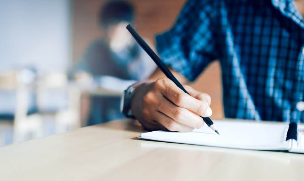 student writing a test in an exam room