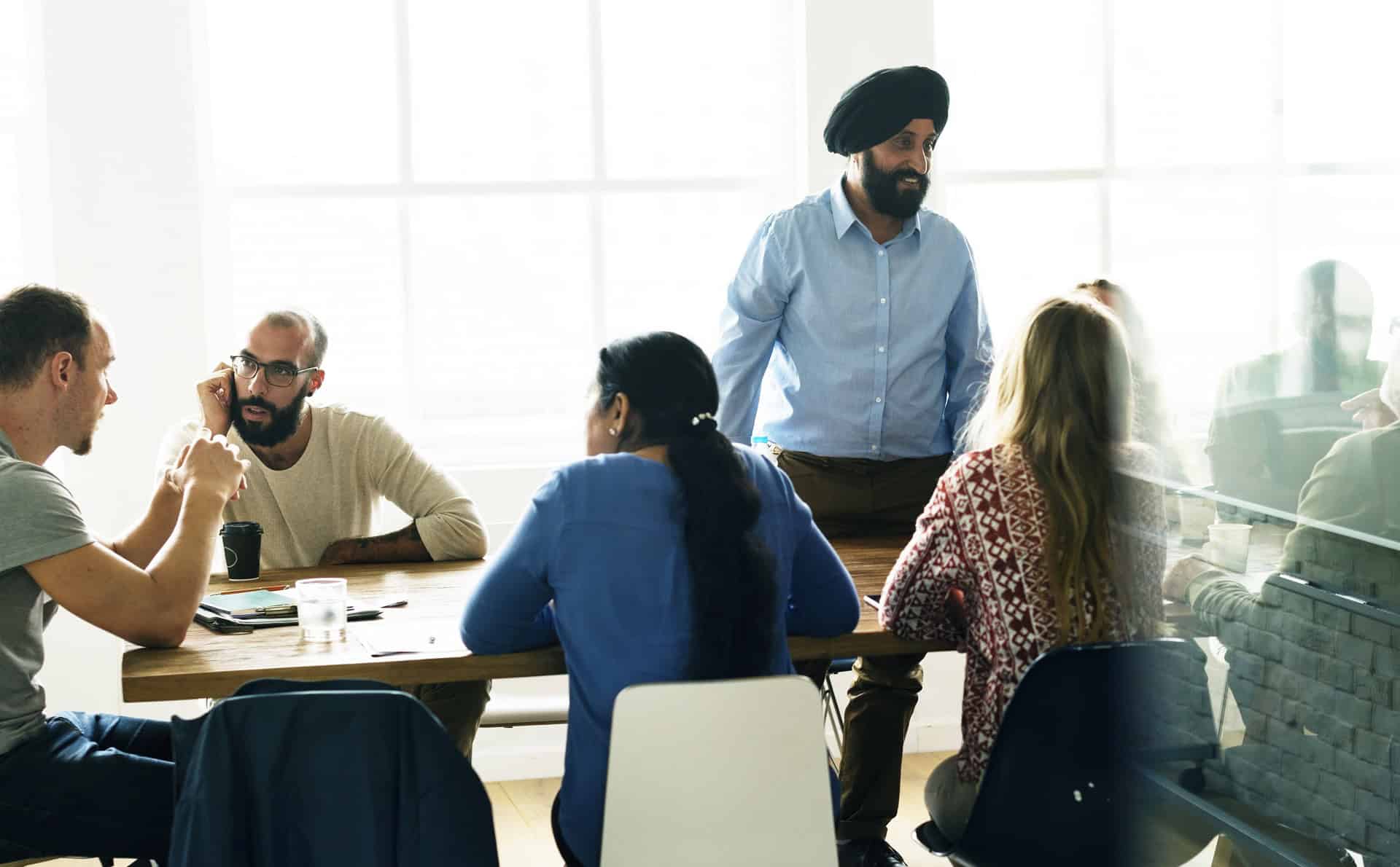 south asian man leading a meeting