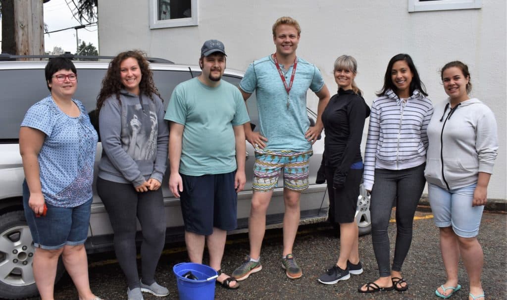 adults with diverse abilities about to wash a car