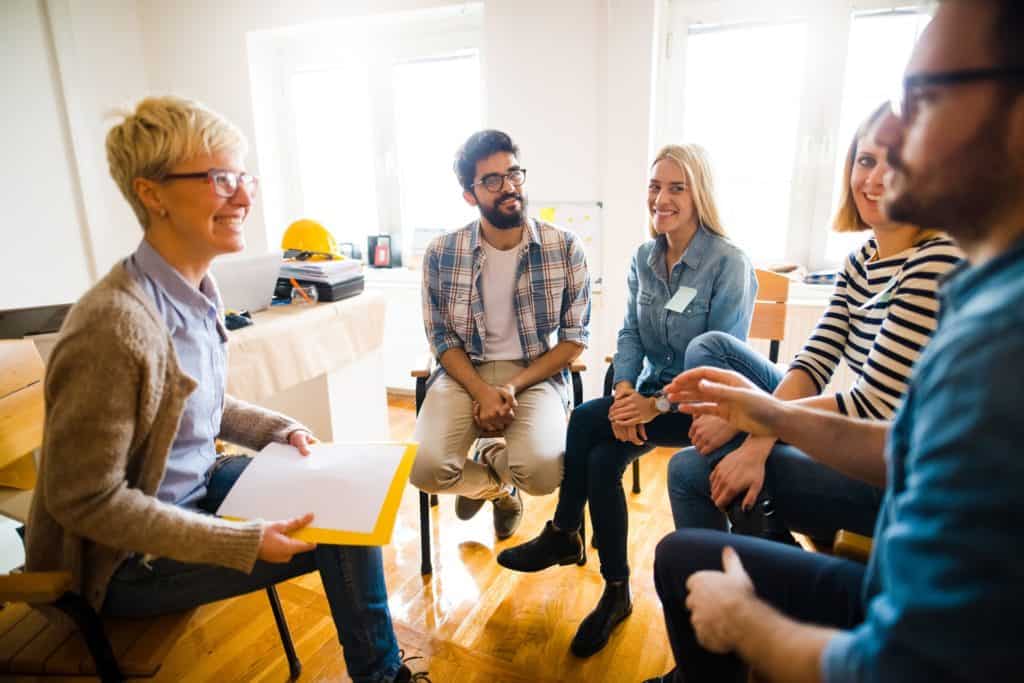 committee members discuss ideas while sitting in a circle