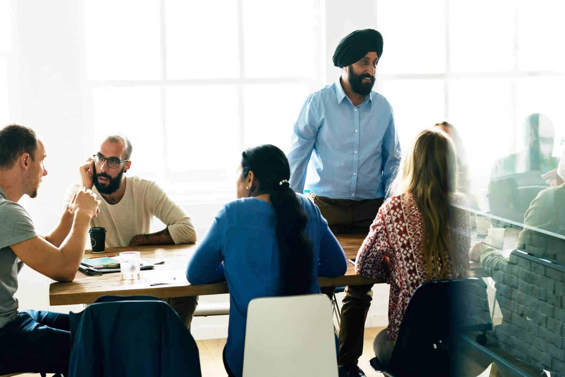 south asian man leading a meeting