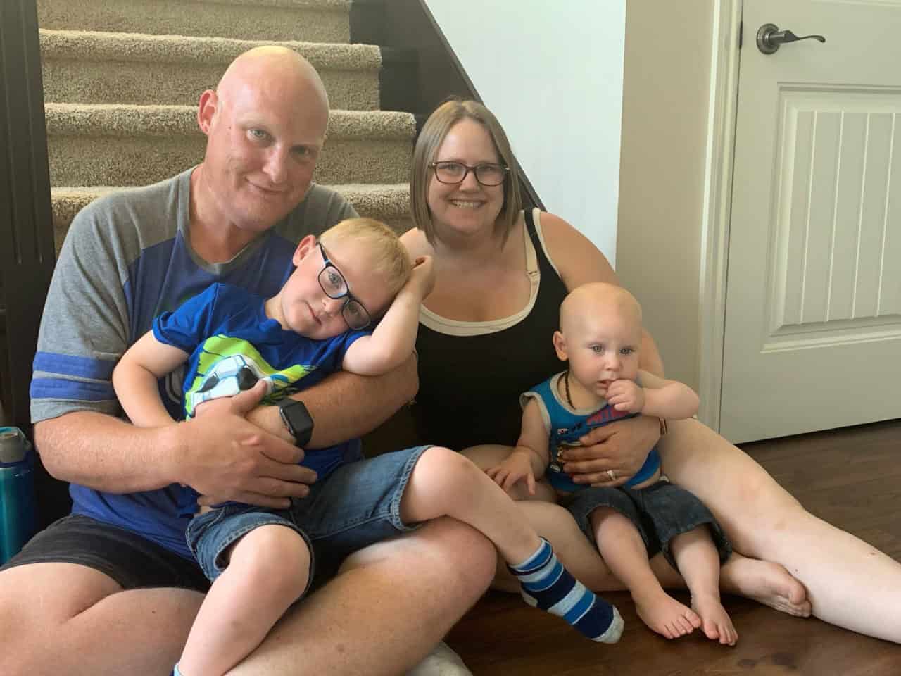 Jenelle (Best4Babies Client) Family of four sitting in front of the stairs