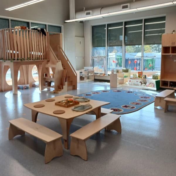 Wooden play structure and bench for young childen in a classroom