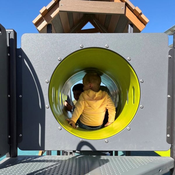 Child inside a slide tunnel about to go down in outdoor playground