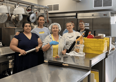 Group of volunteer cooks in industrial kitchen pose together