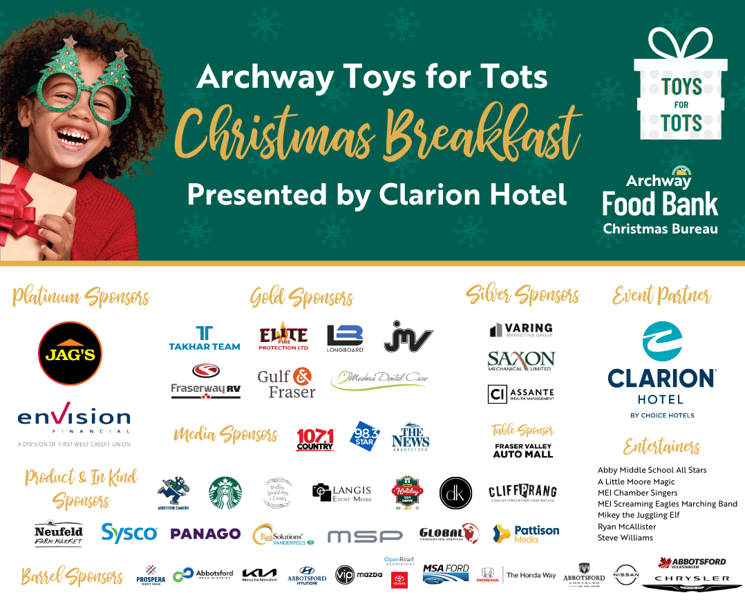 Santa and woman dressed as elf pose with open arms in front of large pile of toys