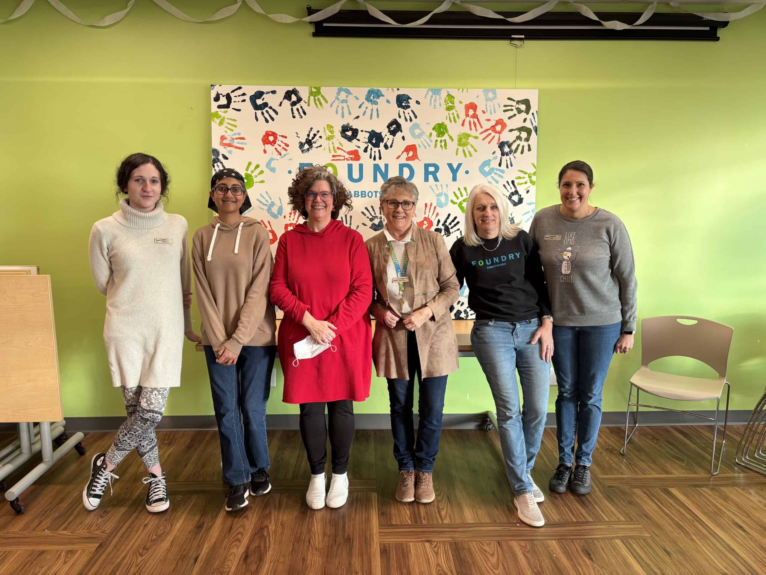 Woman stands in medical office with bright colours on the wall