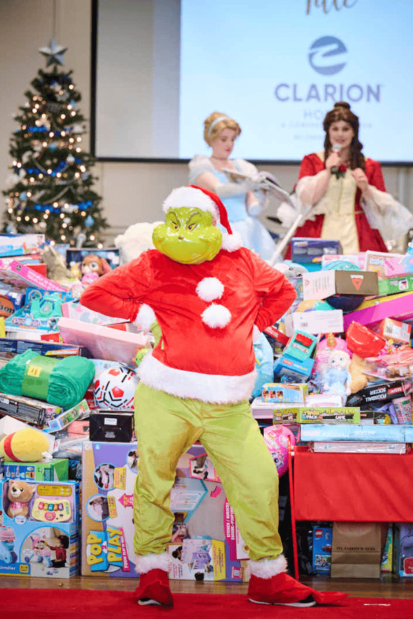 Grinch costume in front of toy pile