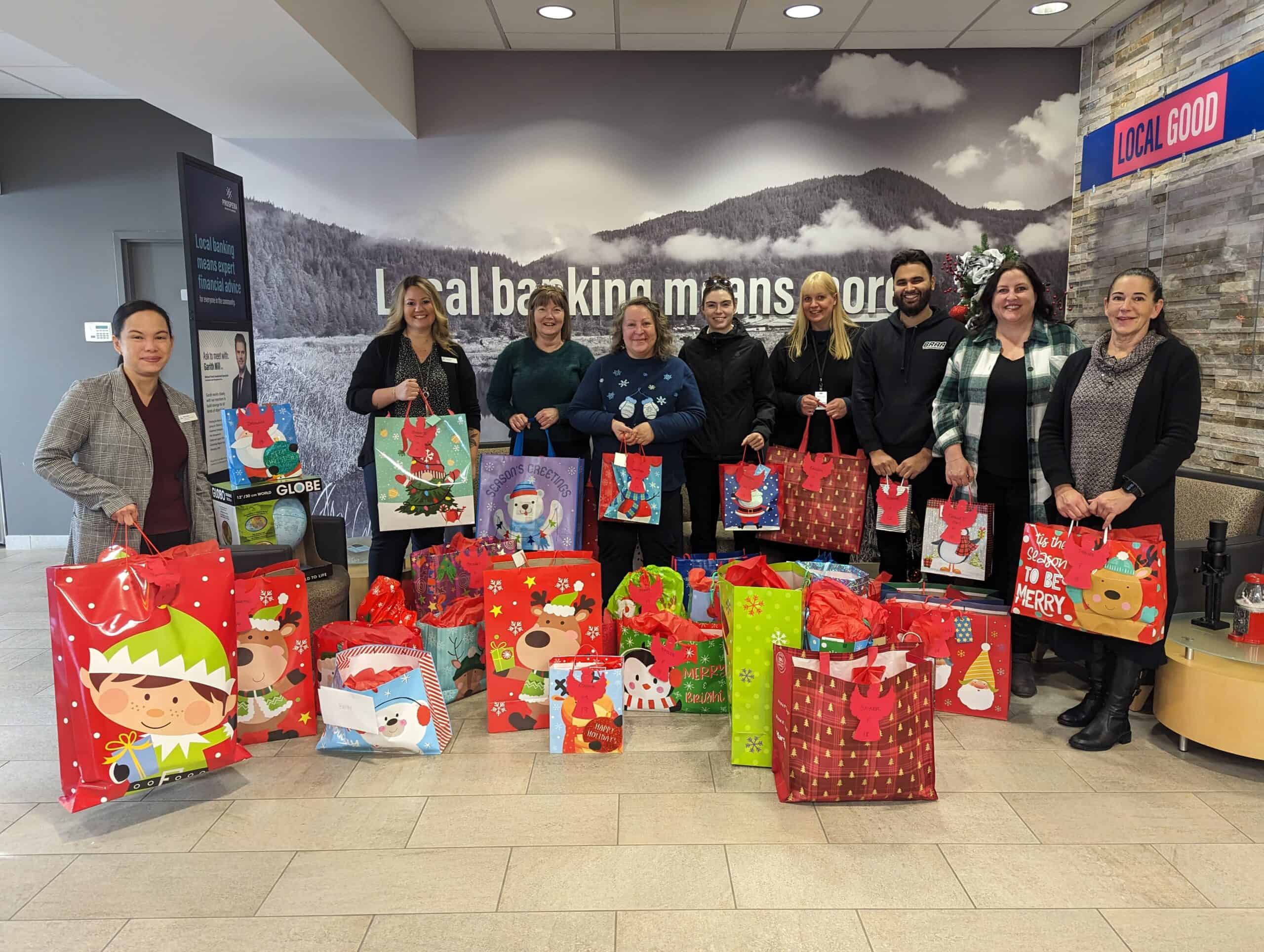 Group poses abreast behind presents