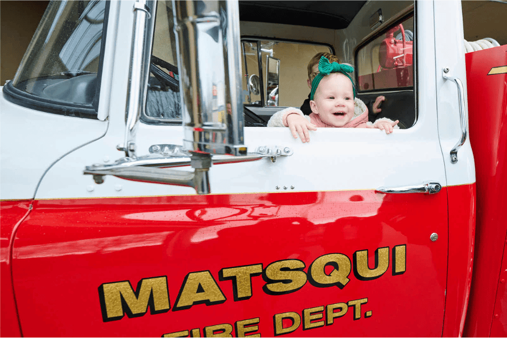 toddler looks out driver side window in fire truck