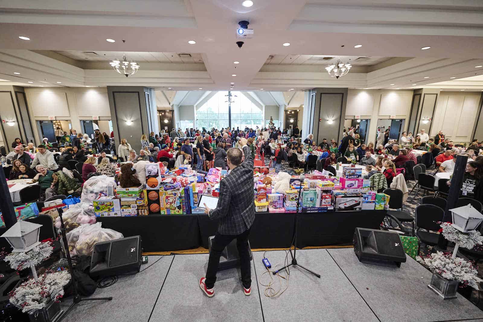 Toys for Tots view of toy pile, attendees and performers from behind the stage