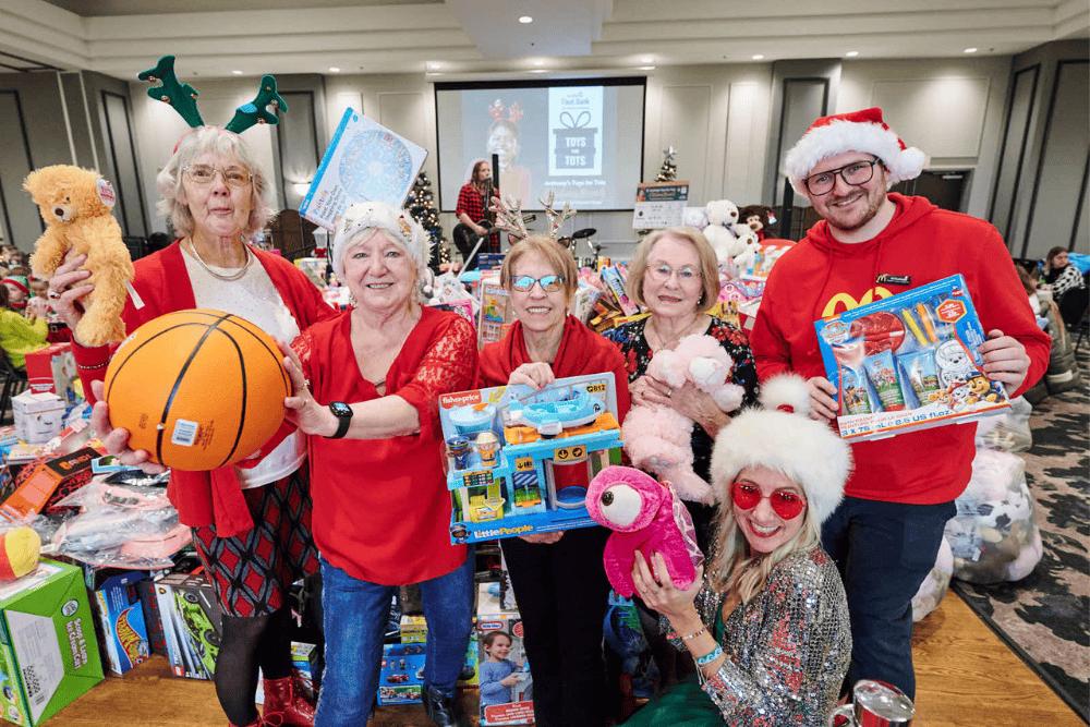 Toys for Tots view of toy pile, attendees and performers from behind the stage