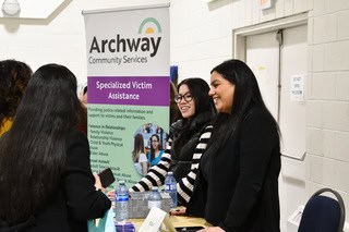 Two women greeting attendees at a booth