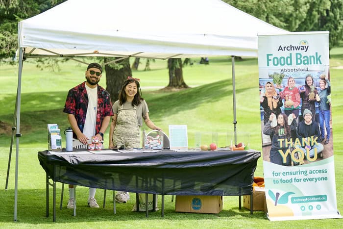 Two people behind a booth posing for a picture
