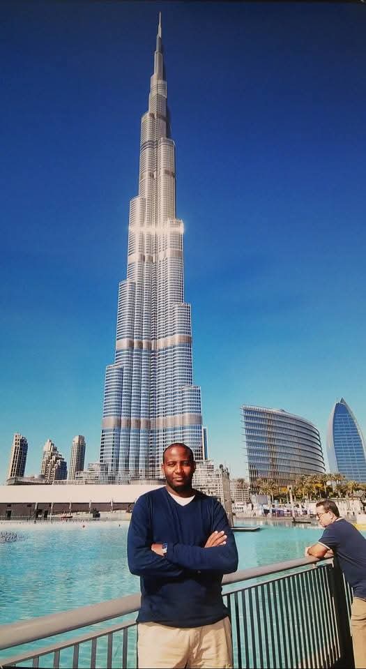 Din posing with arms crossed in front of Burj Khalifa in Dubai