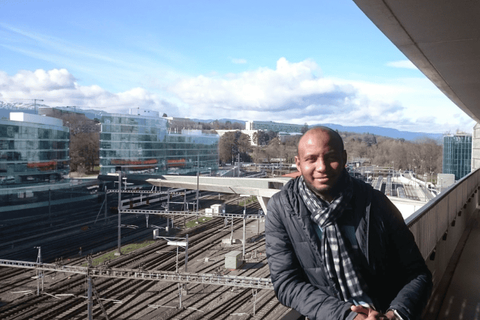 Din standing on bridge above railroads in Geneva, Switzerland