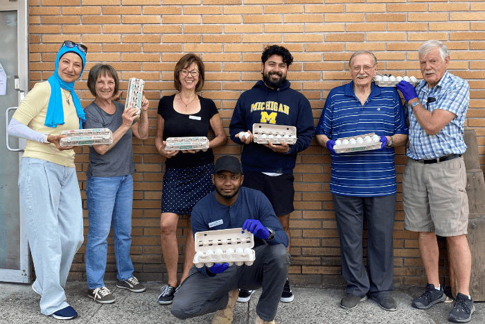 Food Bank staff and volunteers posing and holding egg cartons