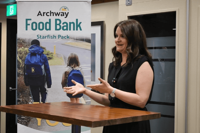 Jana delivering speech behind podium table