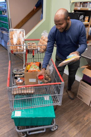Din putting food items in buggie at Archway Food Bank