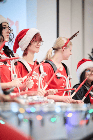 Toys for Tots view of toy pile, attendees and performers from behind the stage