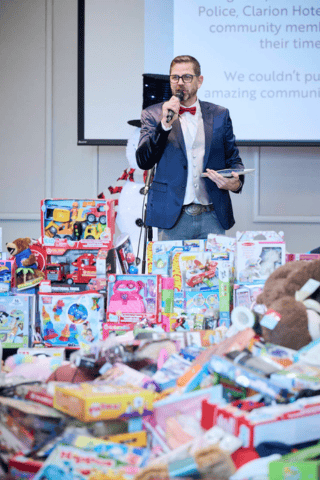 Toys for Tots view of toy pile, attendees and performers from behind the stage