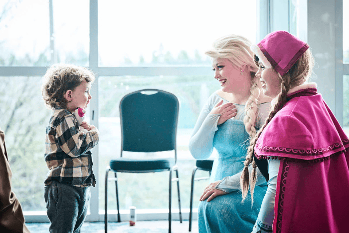 Toys for Tots view of toy pile, attendees and performers from behind the stage