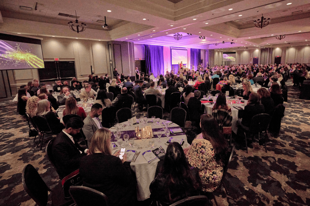 Groups of people sitting at tables in a banquet hall.