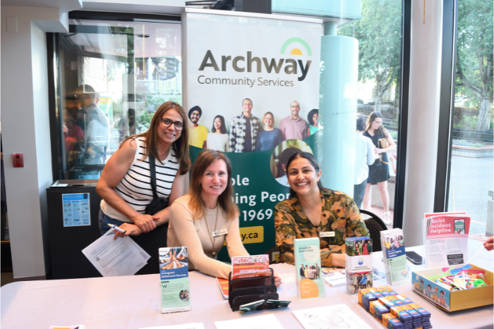 3 women posing for a picture in front of a booth.
